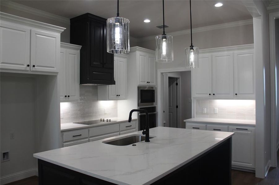Kitchen featuring a sink, black electric cooktop, white cabinetry, backsplash, and recessed lighting Kitchen featuring a sink, black electric cooktop, white cabinetry, backsplash, and recessed lighting