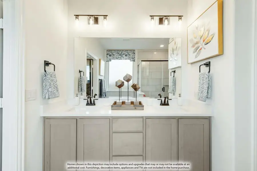 Bathroom double vanity with gray cabinets, white countertops, dual sinks, and large mirror with overhead lighting