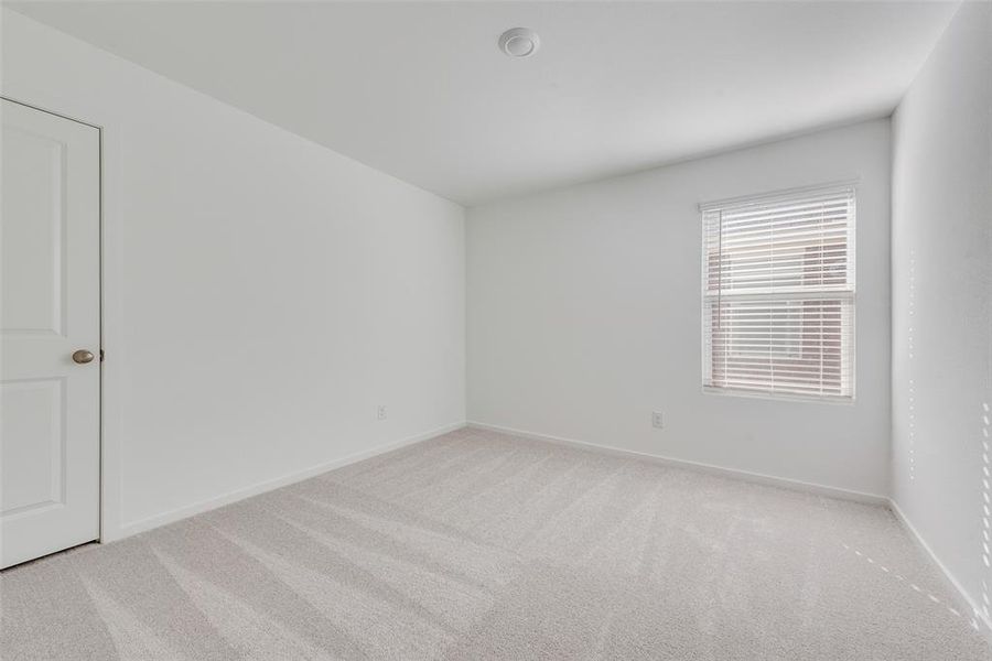 Empty room with light colored carpet