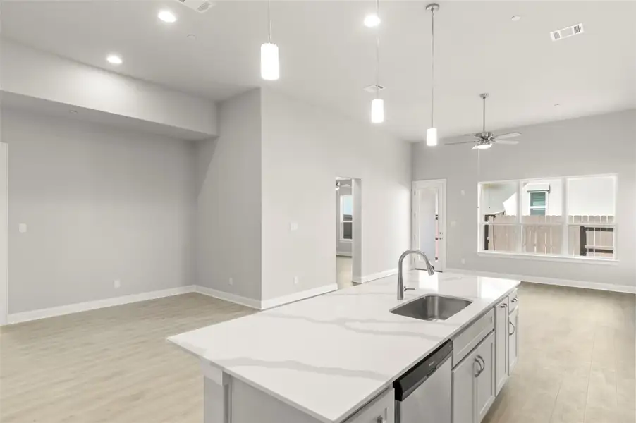 Kitchen with open floor plan, light wood-style floors, dishwasher, decorative light fixtures, and recessed lighting Kitchen with open floor plan, light wood-style floors, dishwasher, decorative light fixtures, and recessed lighting