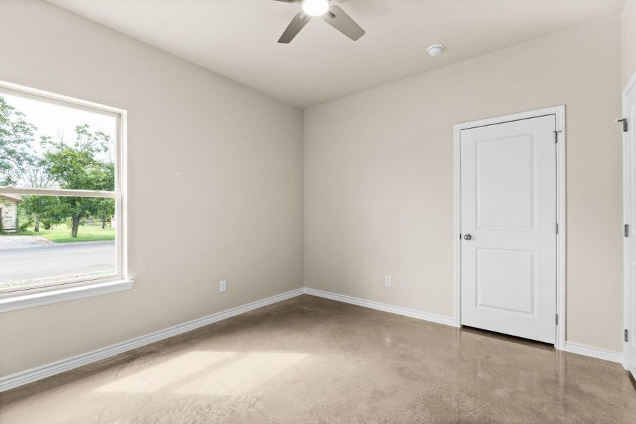 Empty room featuring ceiling fan and concrete flooring