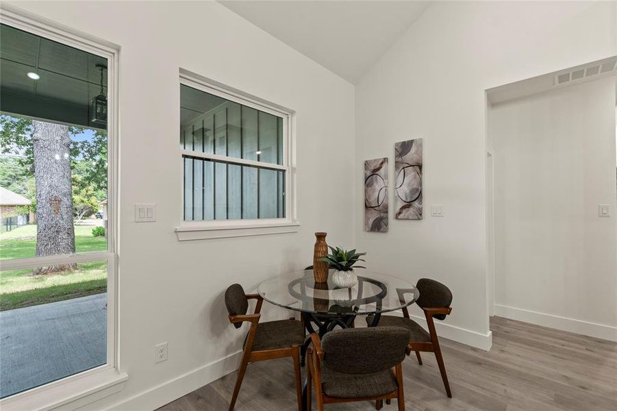 Dining room with baseboards, wood finished floors, and lofted ceiling