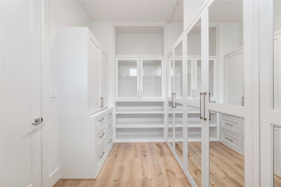 Wardrobe boxes with custom-fabricated doors exude a fashion house feel in the larger of two primary closets. Soft-close hinges are another one of the countless elements of quiet luxury found in this home.