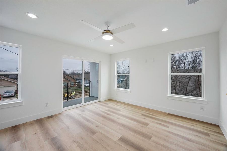 Empty room with ceiling fan and light wood-type flooring