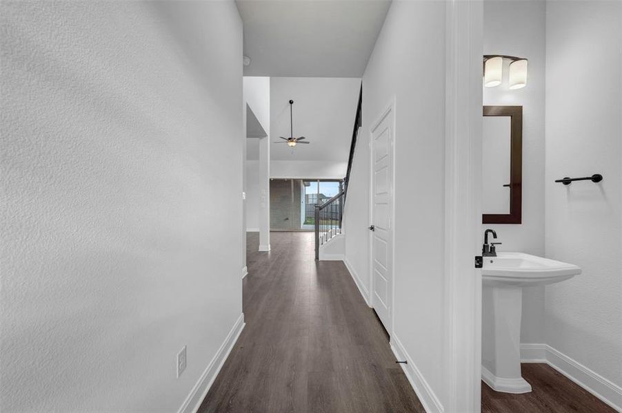 Hallway featuring dark wood-style floors and stairs Hallway featuring dark wood-style floors and stairs