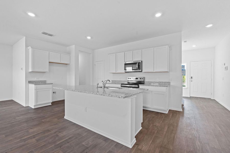 Kitchen featuring white cabinets, light stone countertops, stainless steel appliances, dark wood-style floors, and recessed lighting Kitchen featuring white cabinets, light stone countertops, stainless steel appliances, dark wood-style floors, and recessed lighting