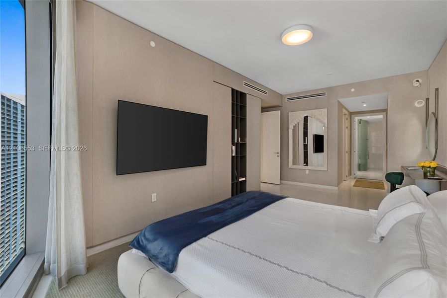 Floor-to-ceiling windows, wall-to-wall integrated paneling, built-in vertical shelving, recessed lighting, and mirrored wall accents