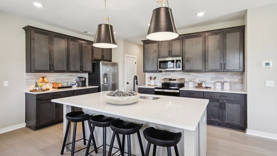 Kitchen with quartz countertops, pendant lighting, and hard-surface flooring