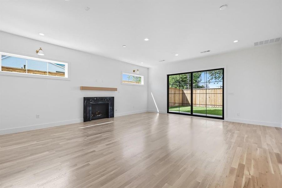 Unfurnished living room with recessed lighting, light wood finished floors, and a fireplace Unfurnished living room with recessed lighting, light wood finished floors, and a fireplace