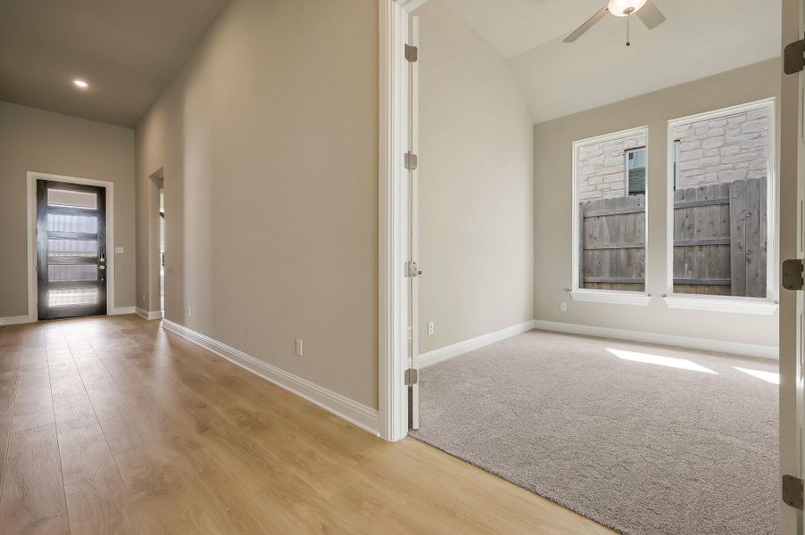 Entryway with light wood-style flooring, ceiling fan, and vaulted ceiling