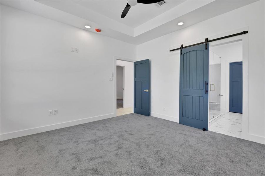 The sliding barn door leads to the primary en-suite bathroom