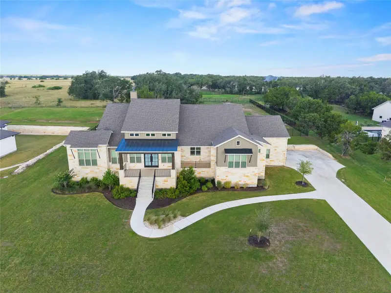 An inviting stone and siding facade welcomes visitors with a covered entry and graceful landscaping. An inviting stone and siding facade welcomes visitors with a covered entry and graceful landscaping.