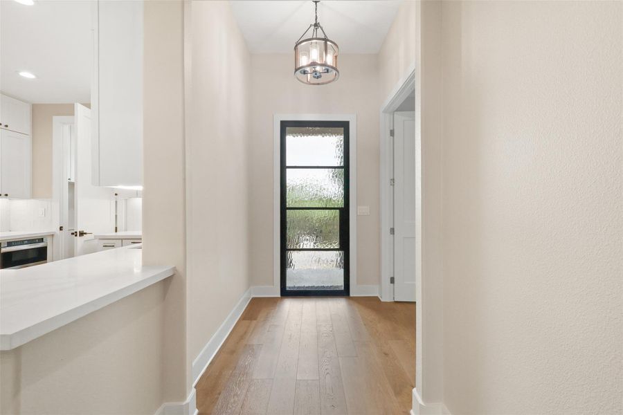 Entryway featuring baseboards, recessed lighting, an inviting chandelier, and light wood finished floors Entryway featuring baseboards, recessed lighting, an inviting chandelier, and light wood finished floors