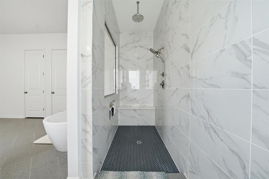 The bathroom features a spacious shower with white marble-style tiled walls and a built-in bench