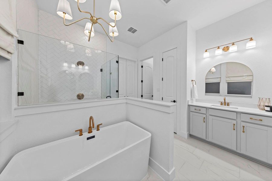 Bathroom with vanity, separate shower and tub, and an inviting chandelier