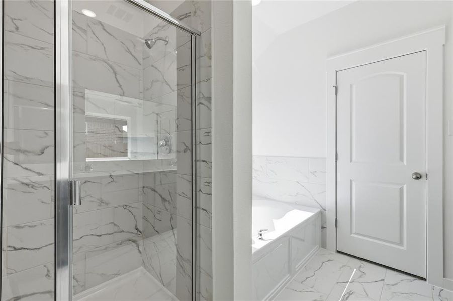 Bathroom featuring a marble finish shower, light marble finish flooring, and a garden tub