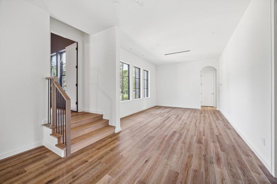 Alternate view of expansive upstairs flex space that can be used as a gameroom filled with natural light from the large windows. Stairs to the left lead to the library and straight ahead are 2 additional secondary bedrooms each with ensuite baths and walk-in closets.