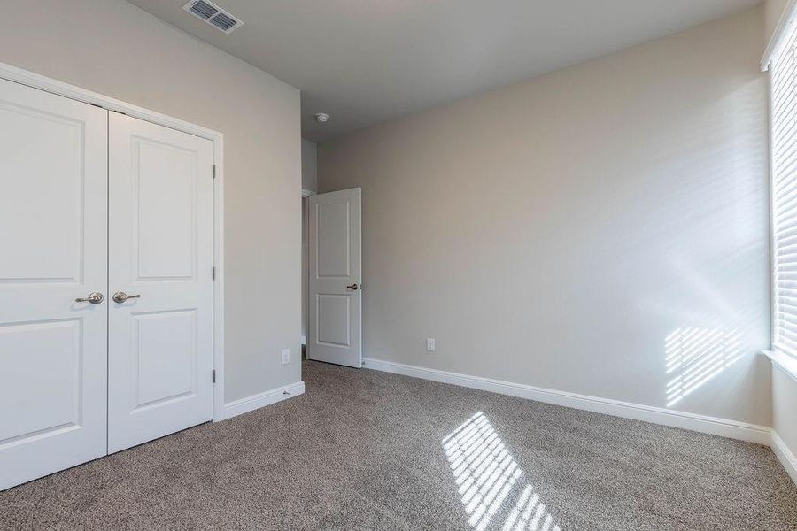 Unfurnished bedroom with carpet flooring and a closet Unfurnished bedroom with carpet flooring and a closet