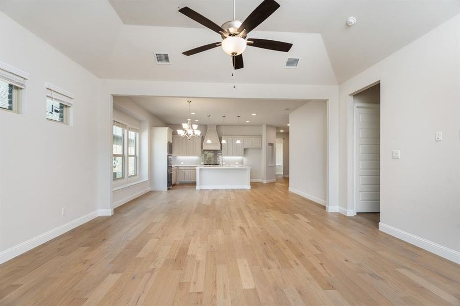 Unfurnished living room with a chandelier, light wood-type flooring, a ceiling fan, and recessed lighting