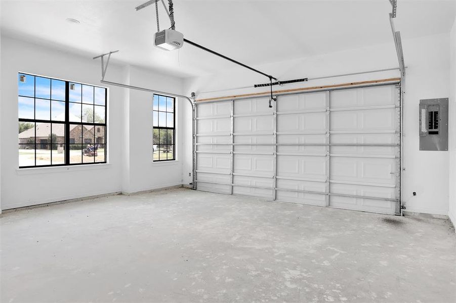 Garage featuring electric panel and a garage door opener