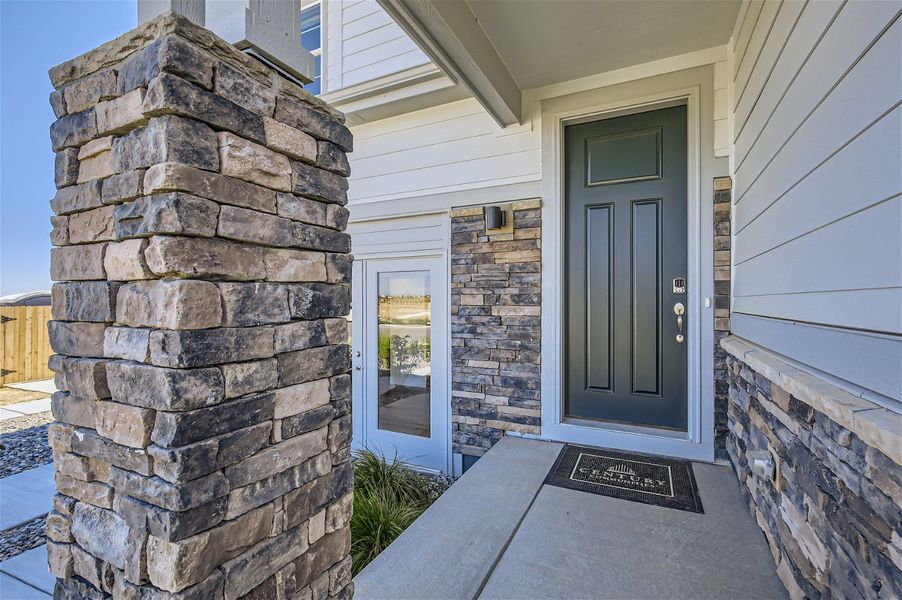 A stone building with a door and a stone wall. A stone building with a door and a stone wall.