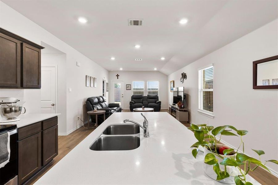 Kitchen featuring open floor plan, dark wood finish cabinetry, wood finished floors, stainless steel range with electric stovetop, and recessed lighting Kitchen featuring open floor plan, dark wood finish cabinetry, wood finished floors, stainless steel range with electric stovetop, and recessed lighting