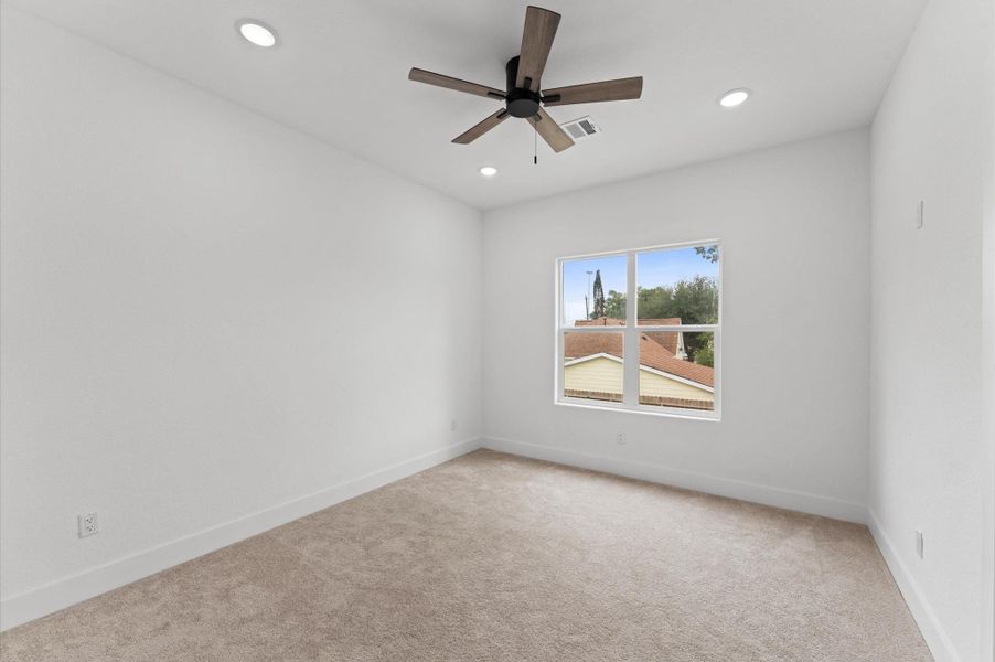 Secondary bedrooms offer carpet and high ceilings. This is Bedroom 2.