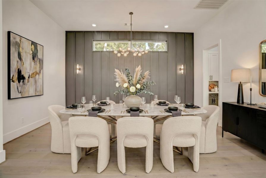 Completely open to the living area is a private dining room with stunning accent wall. Virtually staged photo.