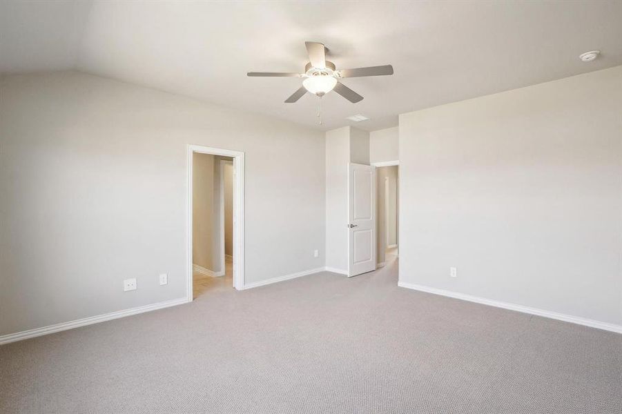 Unfurnished room with light colored carpet, a ceiling fan, and vaulted ceiling Unfurnished room with light colored carpet, a ceiling fan, and vaulted ceiling