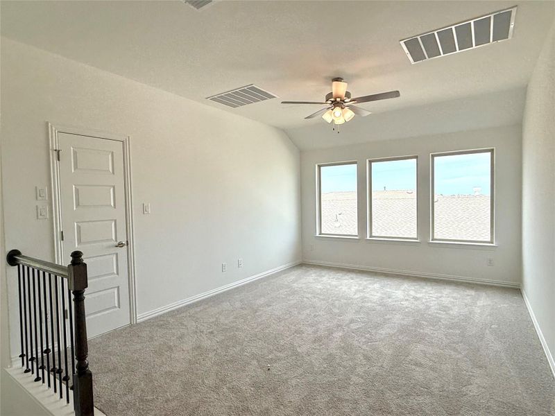Unfurnished room featuring carpet, ceiling fan, and lofted ceiling Unfurnished room featuring carpet, ceiling fan, and lofted ceiling
