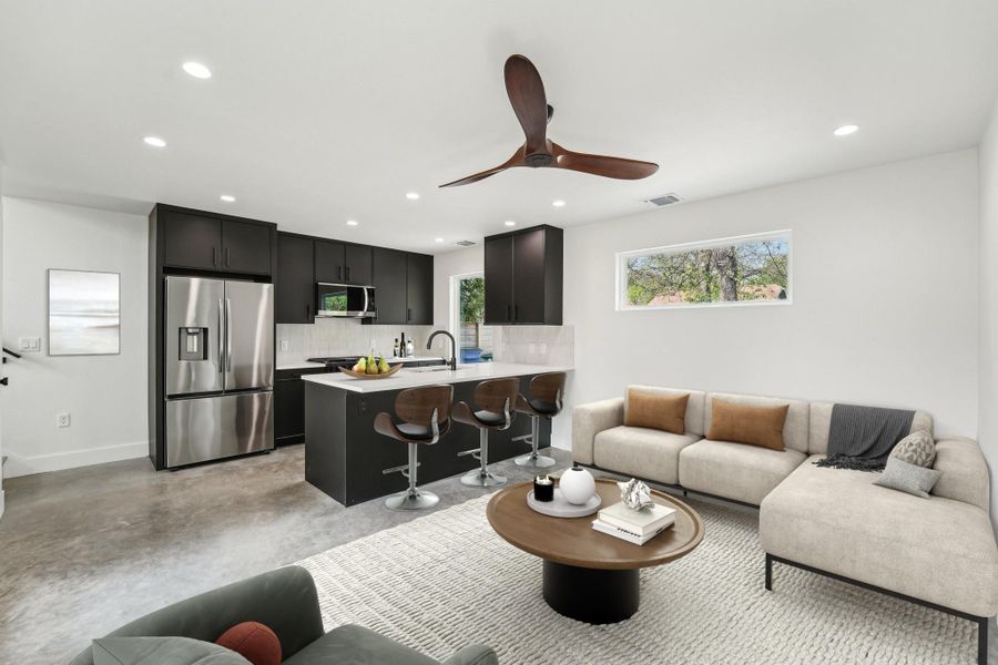 Living room with healthy amount of natural light, recessed lighting, baseboards, ceiling fan, and concrete flooring