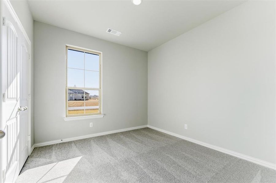 Unfurnished bedroom featuring light carpet and baseboards