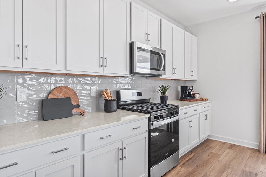 A kitchen with white cabinets.