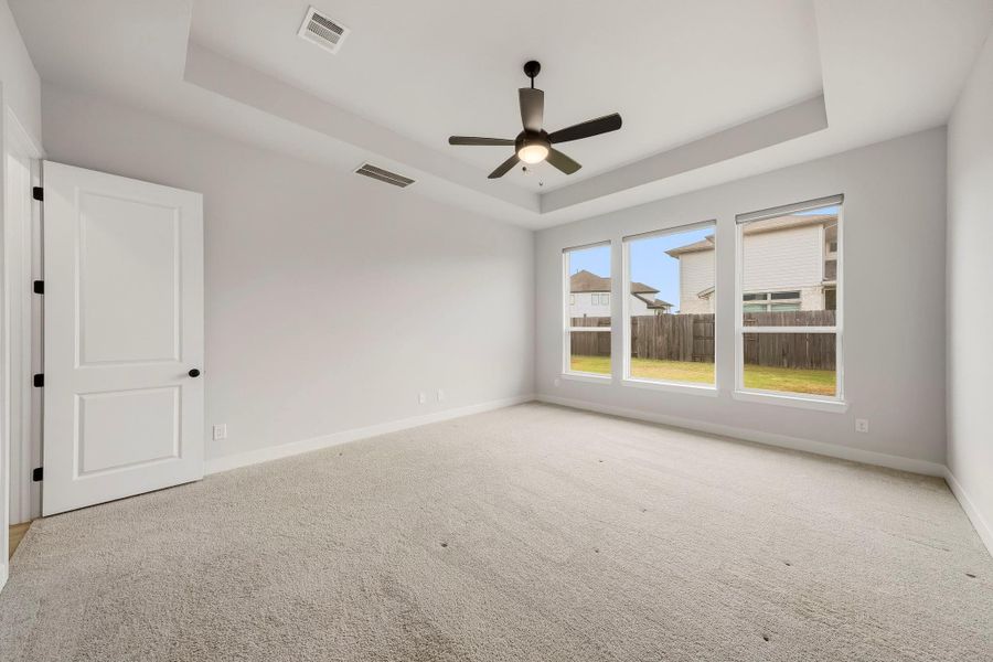 Windows dressed with sleek roller shades provide effortless privacy and light control while allowing natural light to enhance the bedroom’s serene, upscale ambiance.