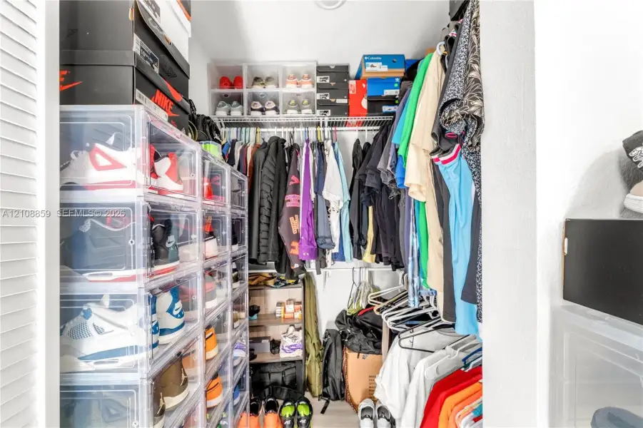 Reach-in closet featuring wire shelving and white louvered doors