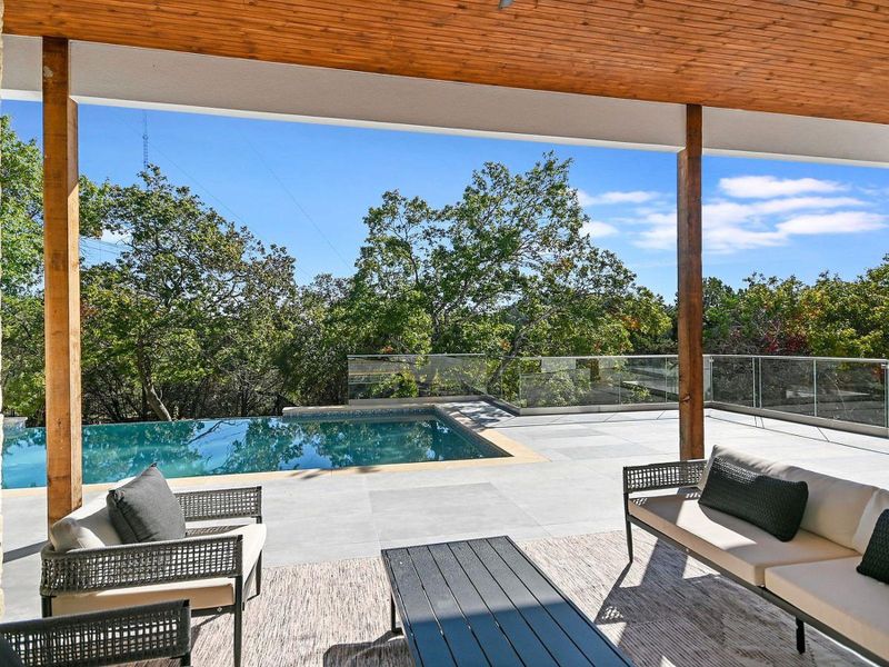 An inviting covered patio offers seamless indoor-outdoor living next to a sparkling infinity pool. An inviting covered patio offers seamless indoor-outdoor living next to a sparkling infinity pool.