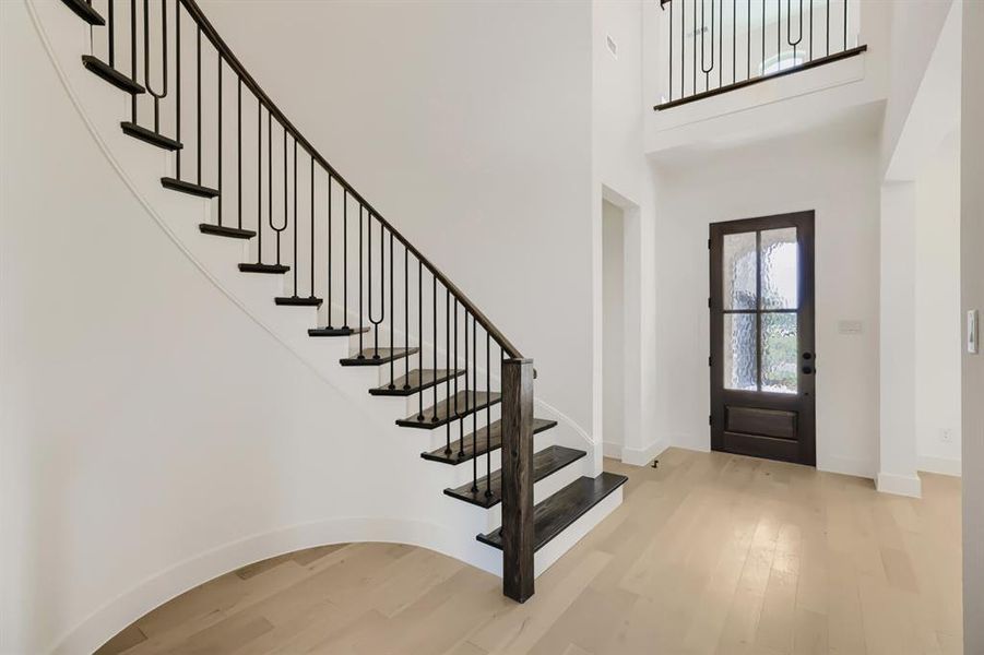 Curved staircase featuring dark wood treads and wrought iron balusters Curved staircase featuring dark wood treads and wrought iron balusters