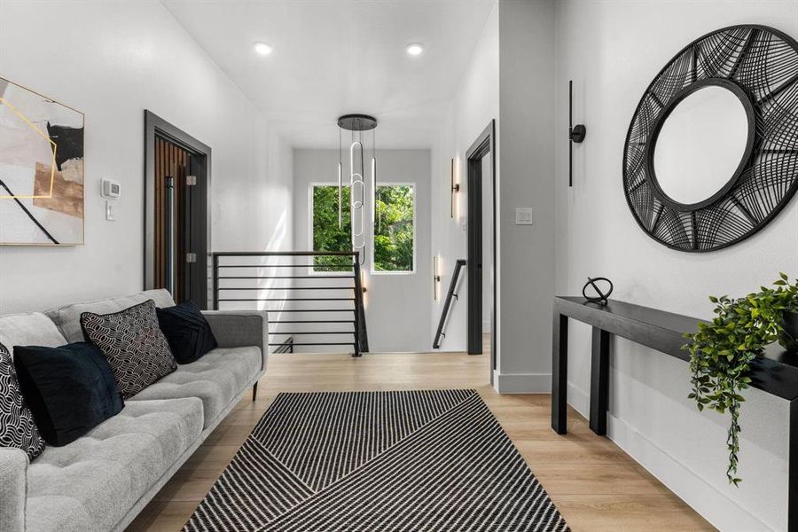 Living area with light wood-style floors and recessed lighting