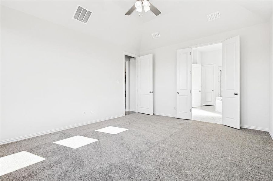Unfurnished bedroom with carpet floors, a ceiling fan, and vaulted ceiling Unfurnished bedroom with carpet floors, a ceiling fan, and vaulted ceiling