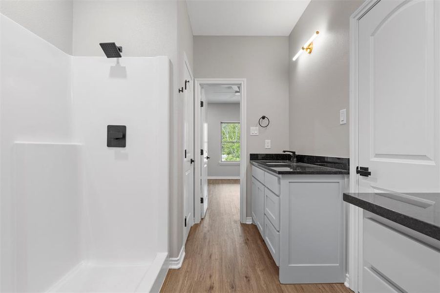 Bathroom with vanity, light wood-style flooring, and a stall shower
