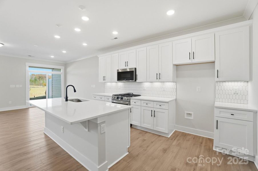 Kitchen with white cabinetry and quartz counters
