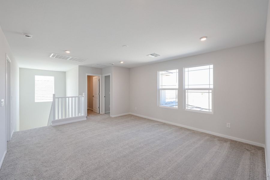 A room with a white wall and windows.