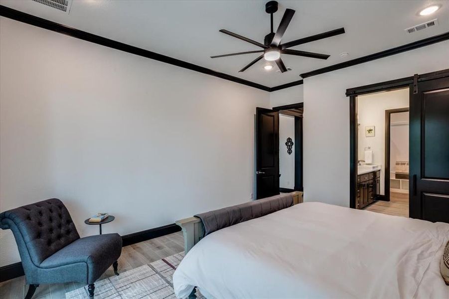 Bedroom with a barn door, light look tile -style flooring, a ceiling fan, recessed lighting, and crown molding