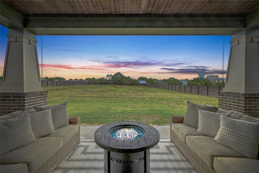Patio terrace at dusk with an outdoor hangout area, a fenced backyard, and a patio