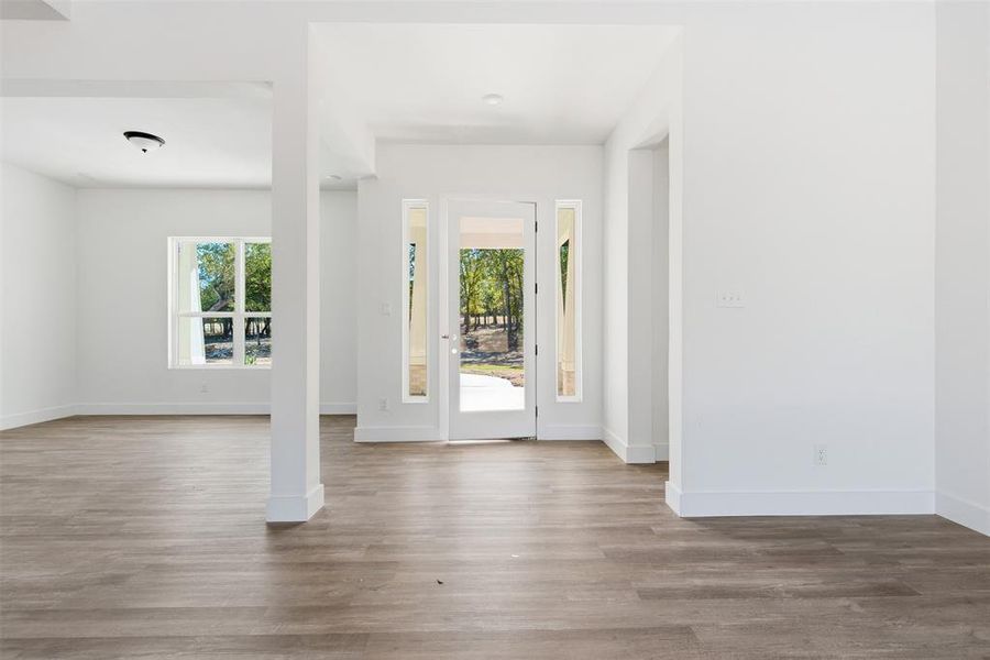 Foyer entrance featuring plenty of natural light and wood finished floors Foyer entrance featuring plenty of natural light and wood finished floors