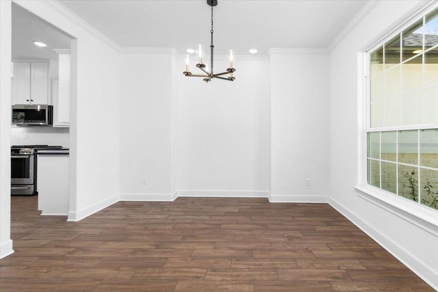 Unfurnished dining area featuring a chandelier, ornamental molding, dark wood-type flooring, recessed lighting, and baseboards Unfurnished dining area featuring a chandelier, ornamental molding, dark wood-type flooring, recessed lighting, and baseboards