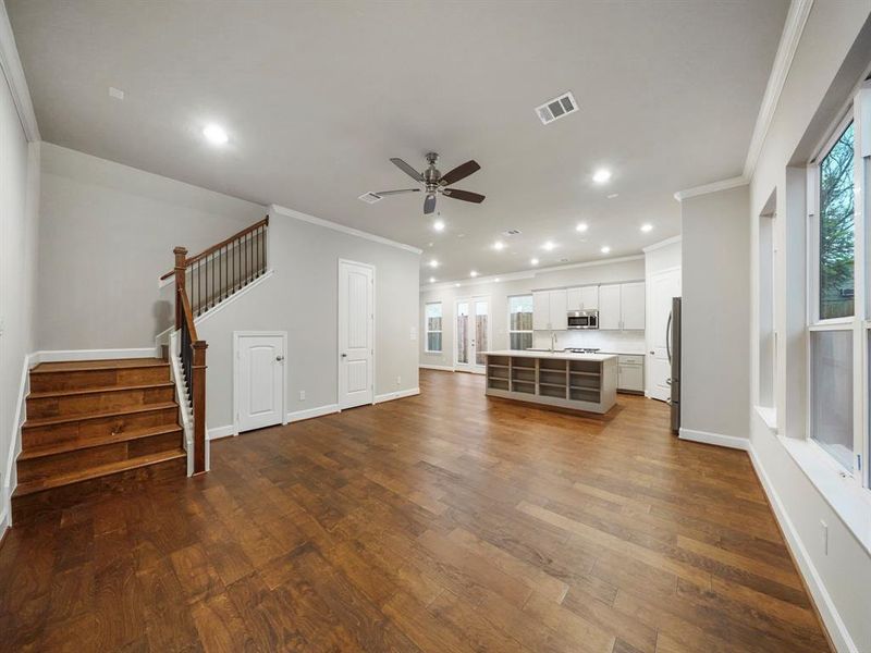 A large space for entertainment and relaxation, this Living Area boasts wood flooring and large windows, with an abundance of natural light. The space opens to the kitchen and dining area, creating the perfect open-concept layout. (Sample photo of a completed Sterling Floor Plan. Image may show alternative features/and or upgrades.)