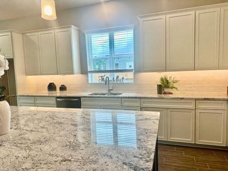 Under cabinet light, sink looks out a window! Granite counterse