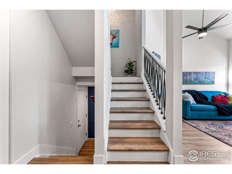 Metal railings and matching treads make for a modern staircase heading up to the 2 upstairs bedrooms.