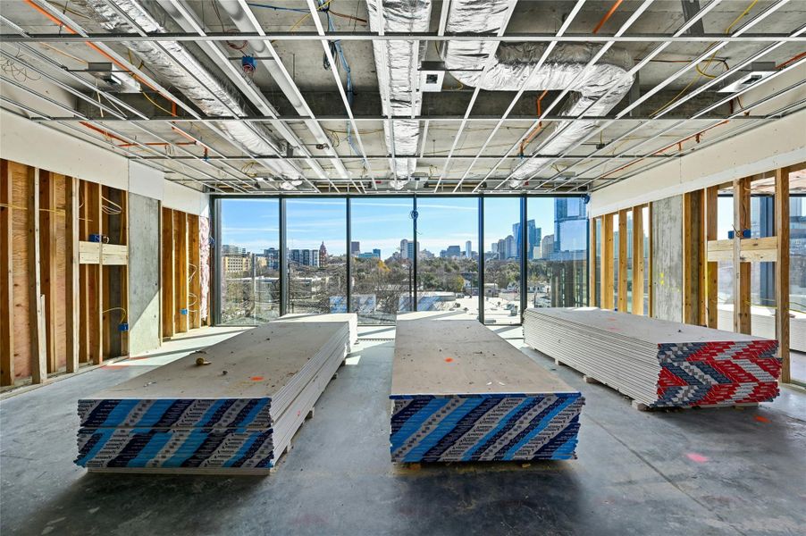 Unfurnished bedroom featuring concrete floors and a city view